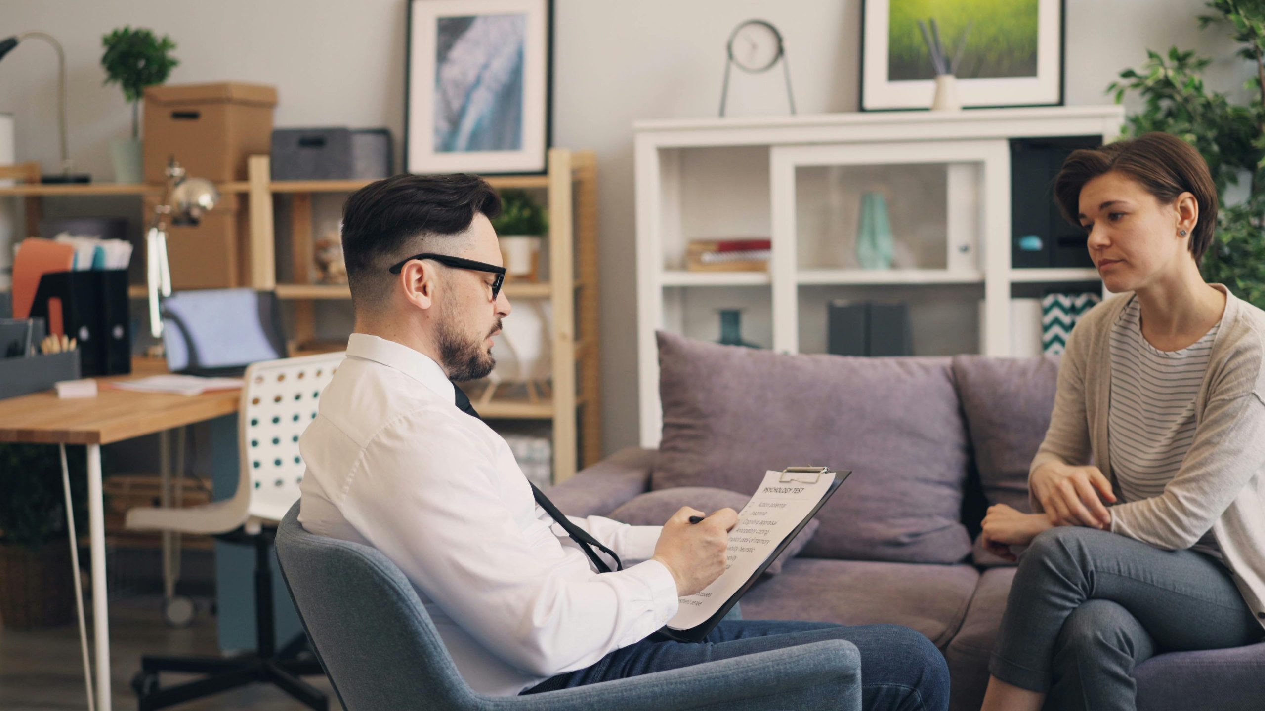 Eingliederungshilfe A therapist engages in a consultation session with a female patient in a cozy office setting.
