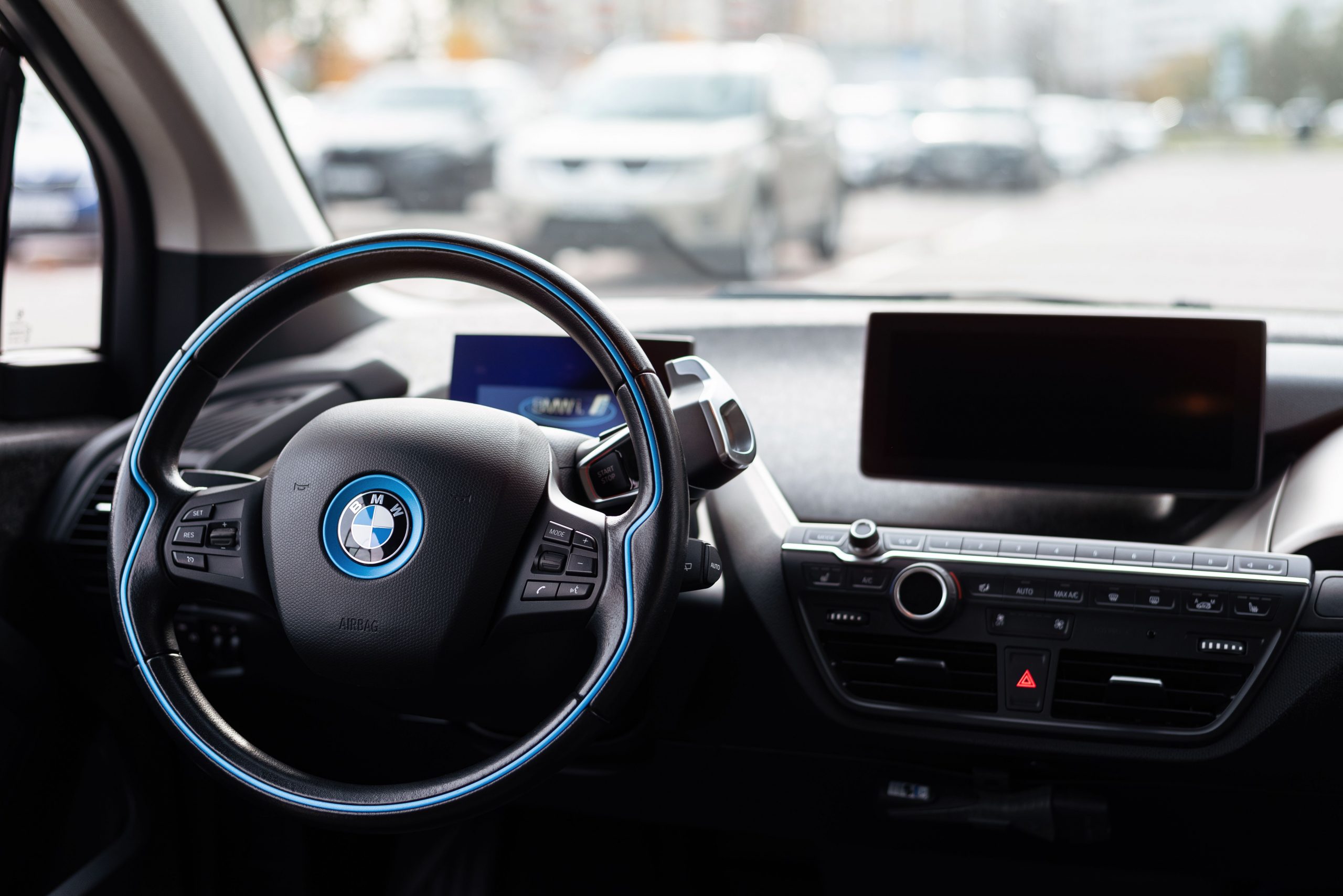 Carsharing Interior of a modern car showcasing sleek dashboard and steering wheel in an urban setting.